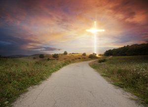 A road leading to a bright cross